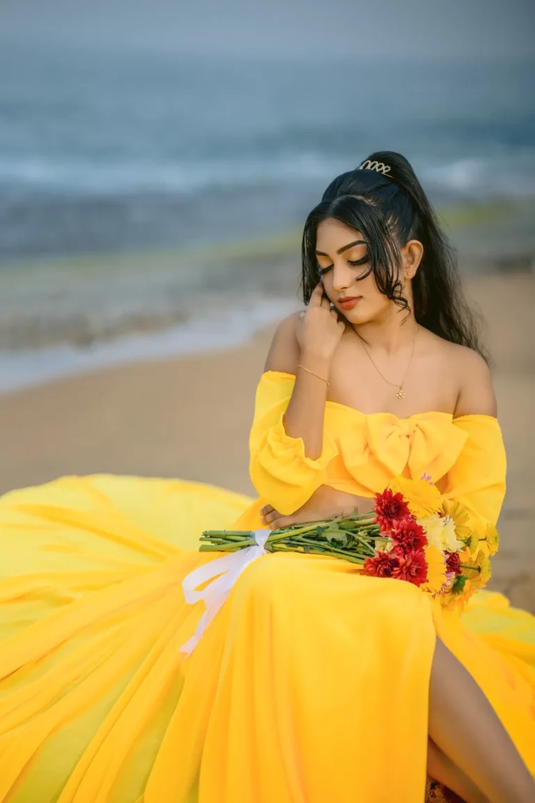 A beautiful young woman in a yellow dress holds a colourful bouquet of flowers, showcasing her beauty.