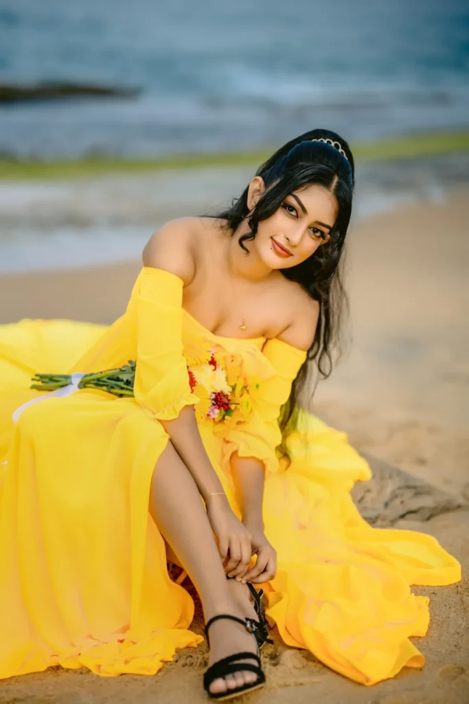 A beautiful young woman in a yellow dress holds a colourful bouquet of flowers, showcasing her beauty.