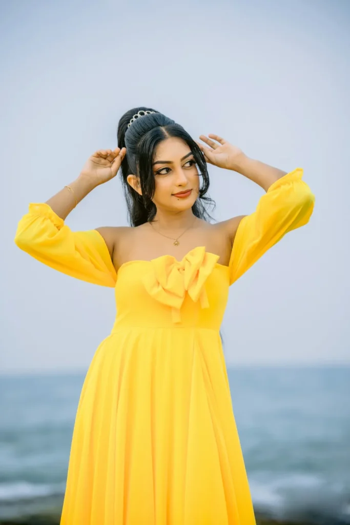 A beautiful young woman in a yellow dress, showcasing her beauty.