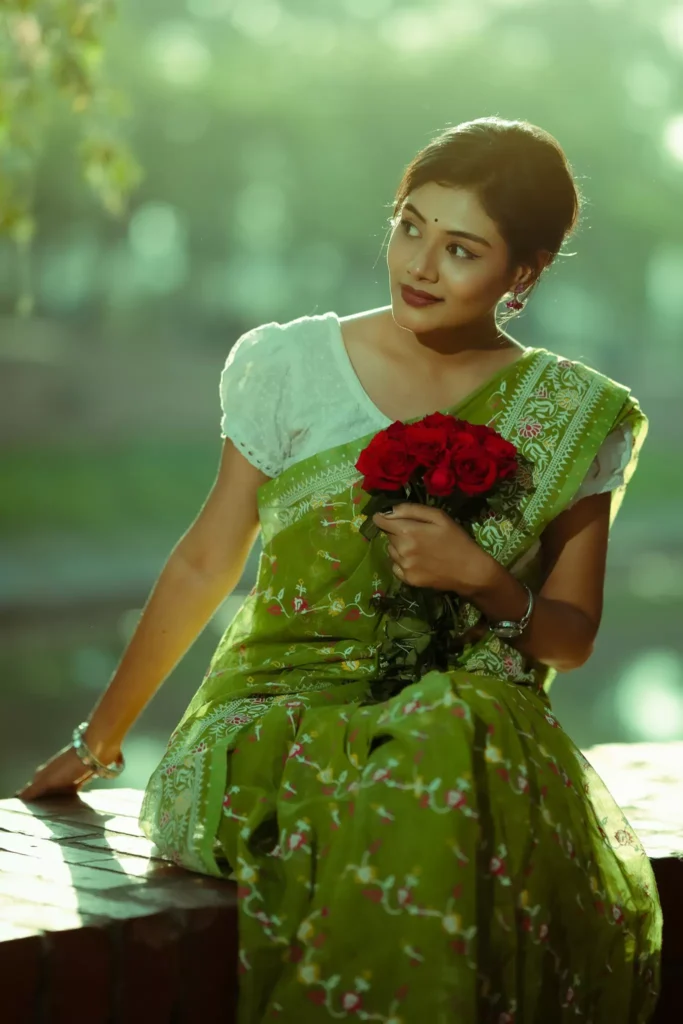 Woman holding red flowers looking sideways.
