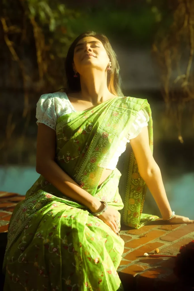 Woman basking in sunlight with eyes closed.