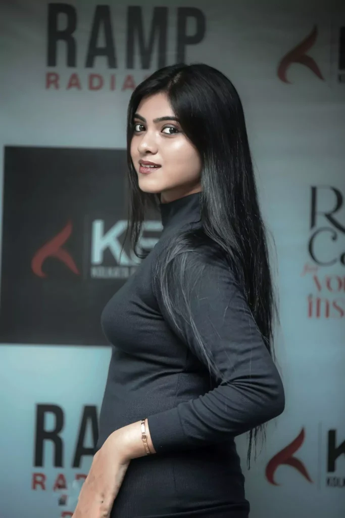 Side profile of woman in black dress posing confidently on ramp backdrop